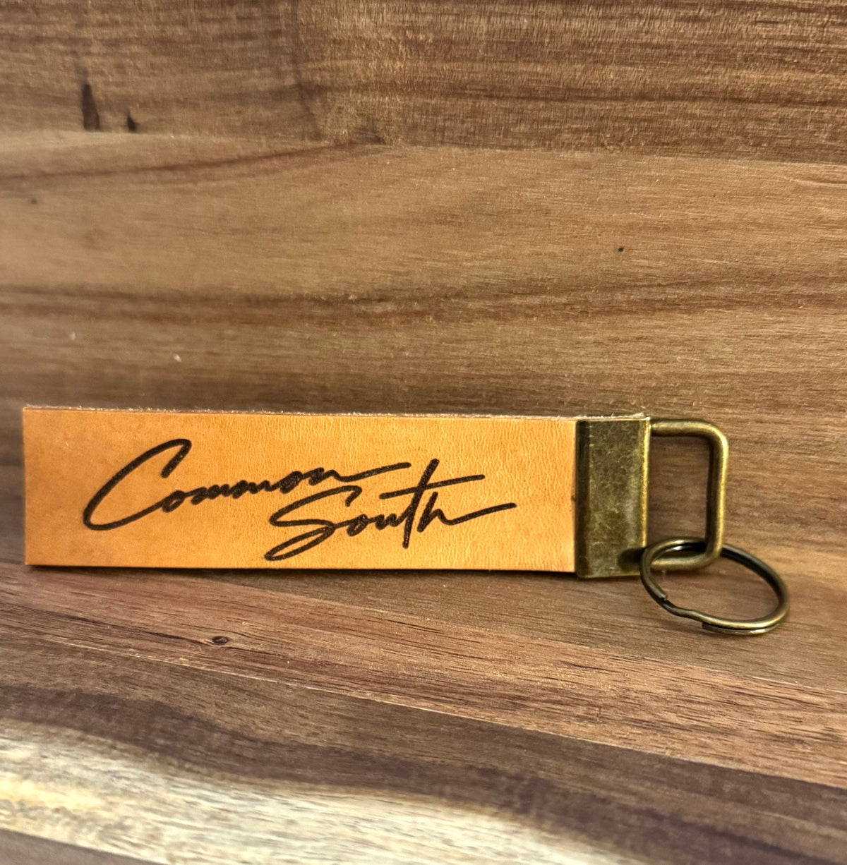 Leather keychain engraved with the Common South signature script